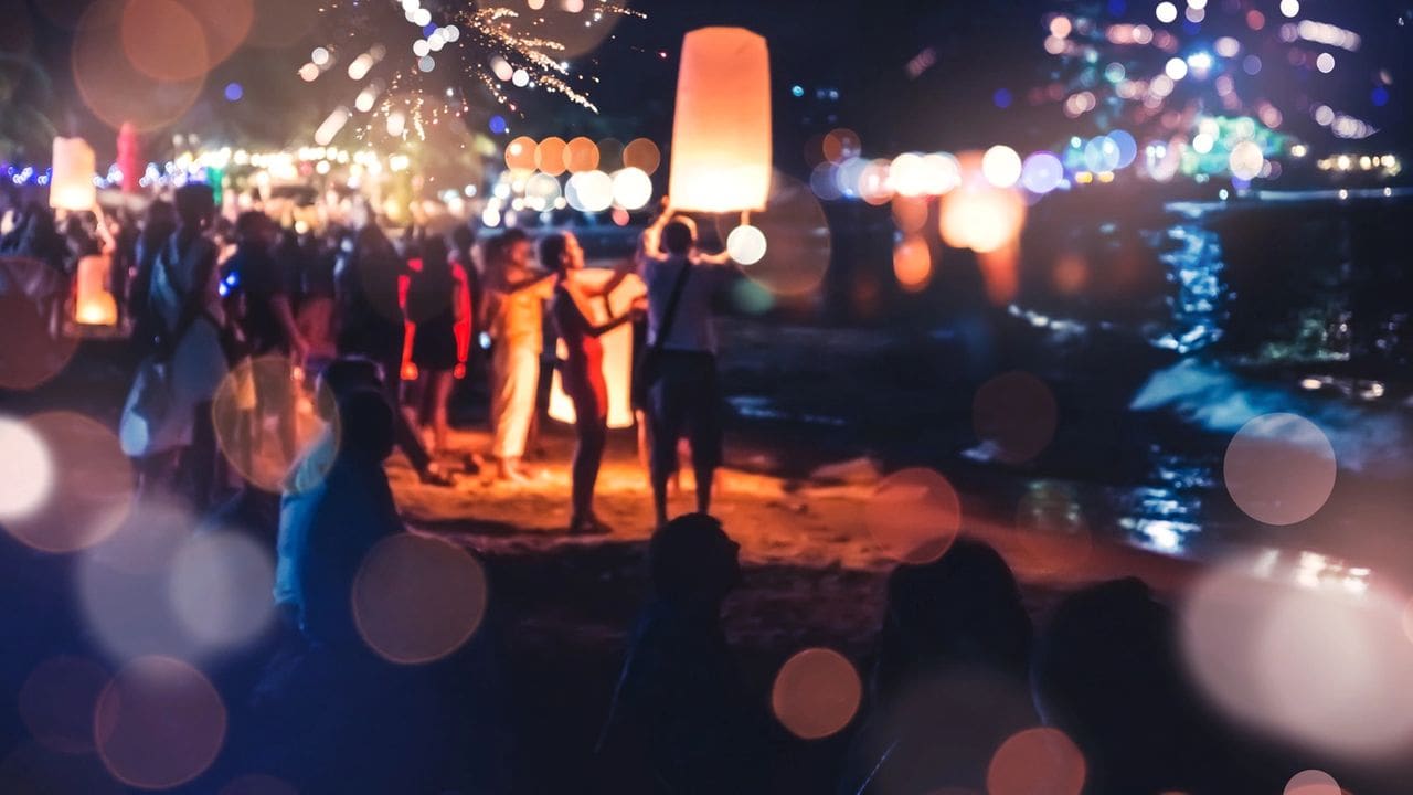 Party of people releasing lanterns into the air at night